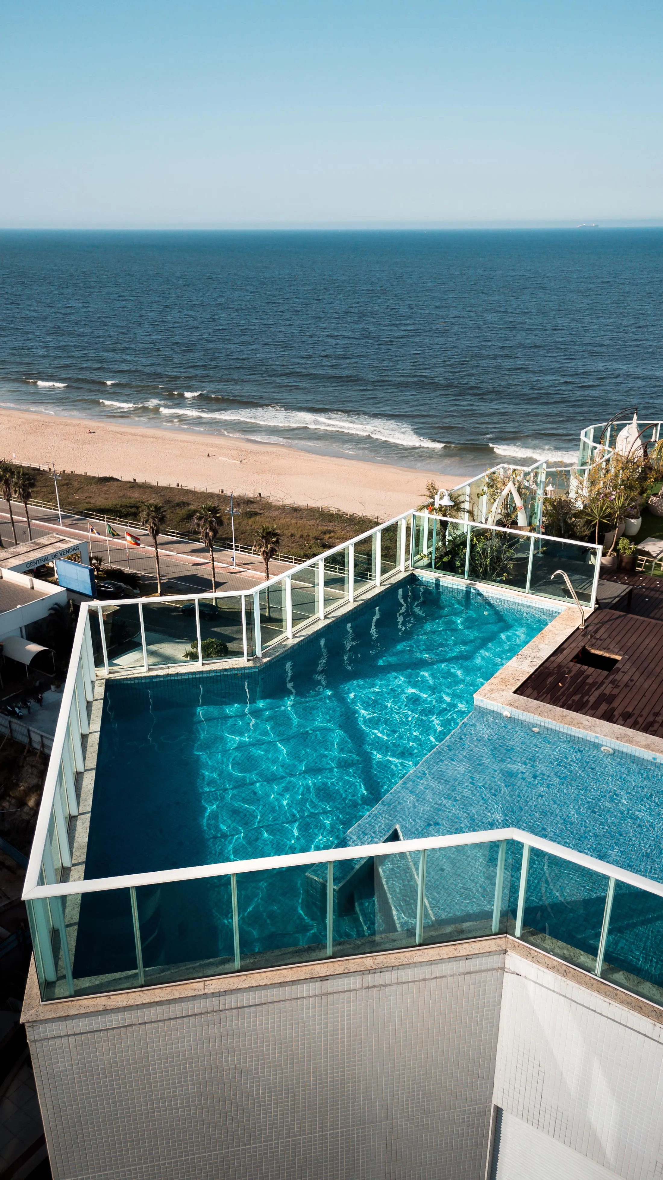 Piscina de cobertura com borda de vidro e o mar ao fundo